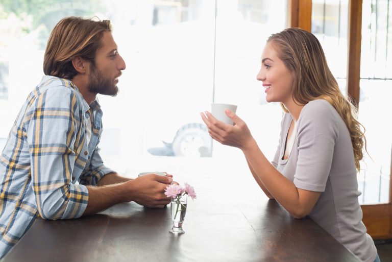 homme et femme discutant assis dans un café