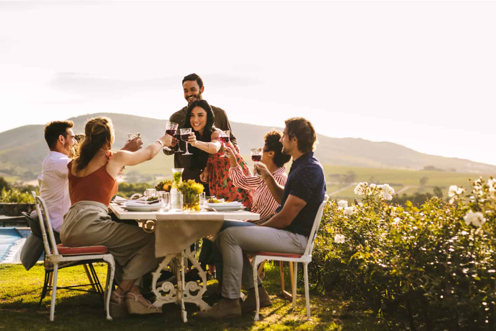 Couple portant un toast avec des amis assis à table pendant la fête