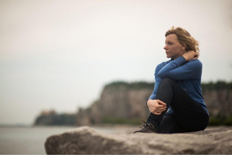 femme assise seule au bord de la mer