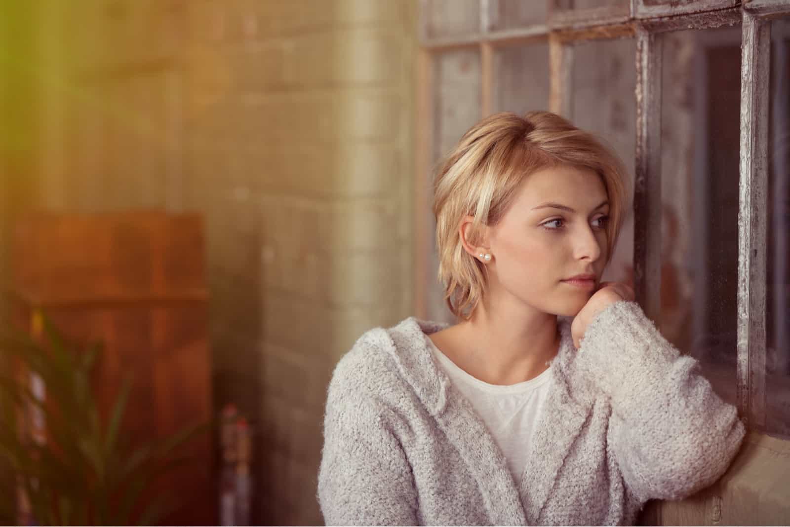 Jeune femme assise à rêvasser