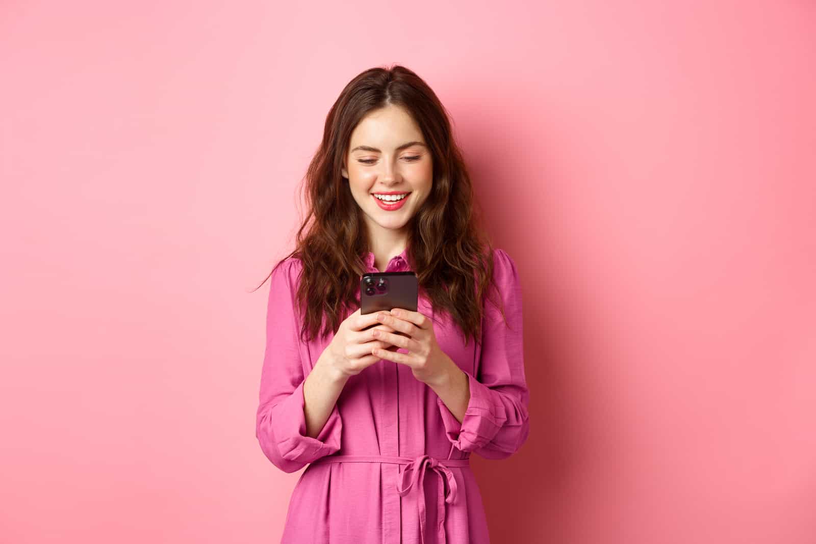 Jeune femme souriante et discutant sur son smartphone