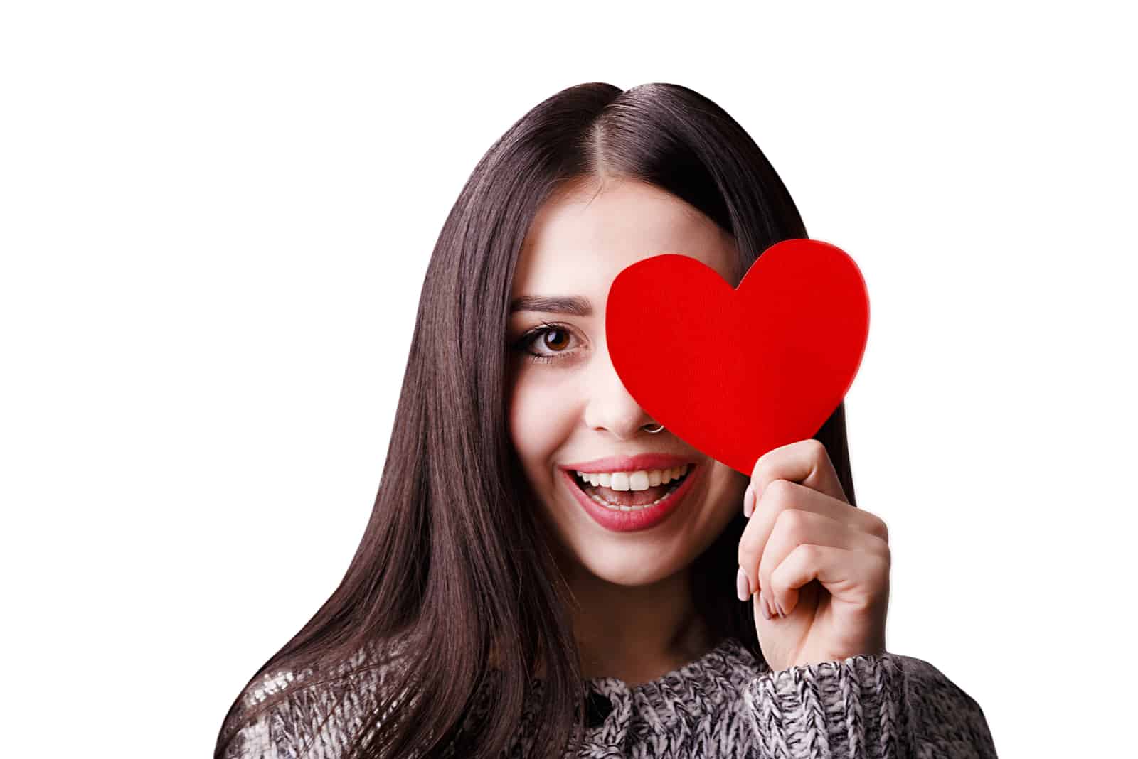Jolie femme souriante gardant le papier coeur rouge par un œil