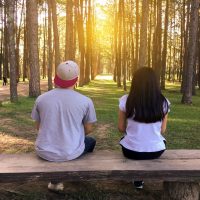 homme et femme assis sur un banc dans une forêt