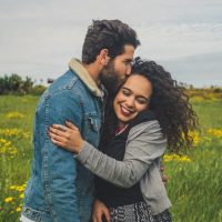 homme embrassant une femme dans un champ