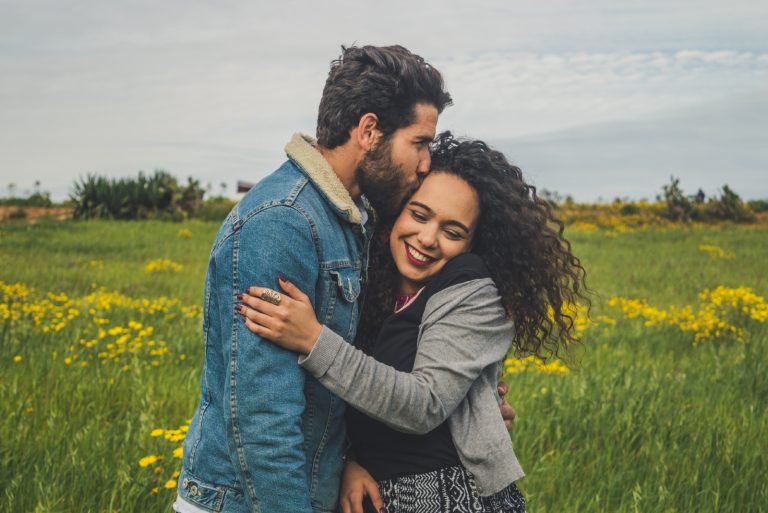 homme embrassant une femme dans un champ