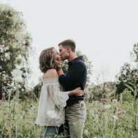 homme et femme s'embrassant sur un champ d'herbe
