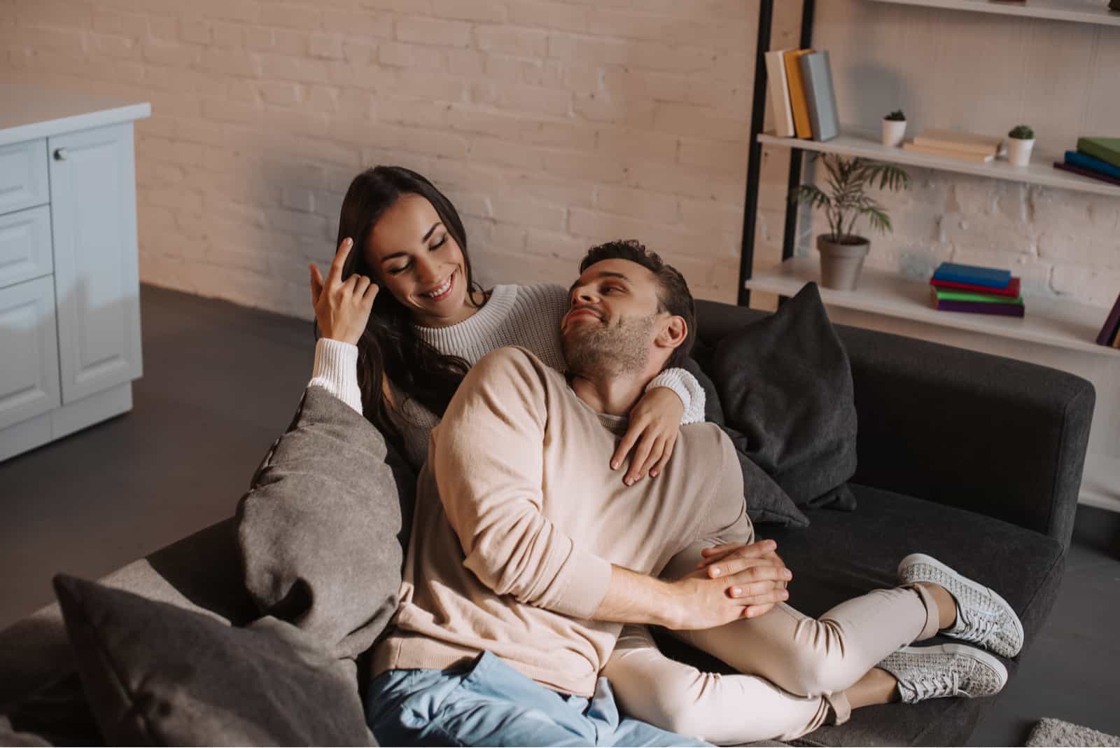 beau couple heureux se détendre ensemble sur un canapé à la maison