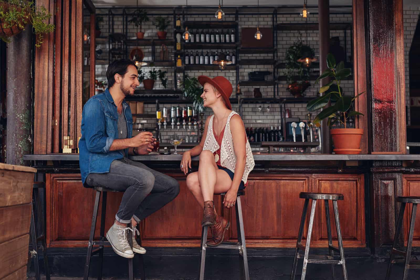 homme et femme parlant assis dans un bar