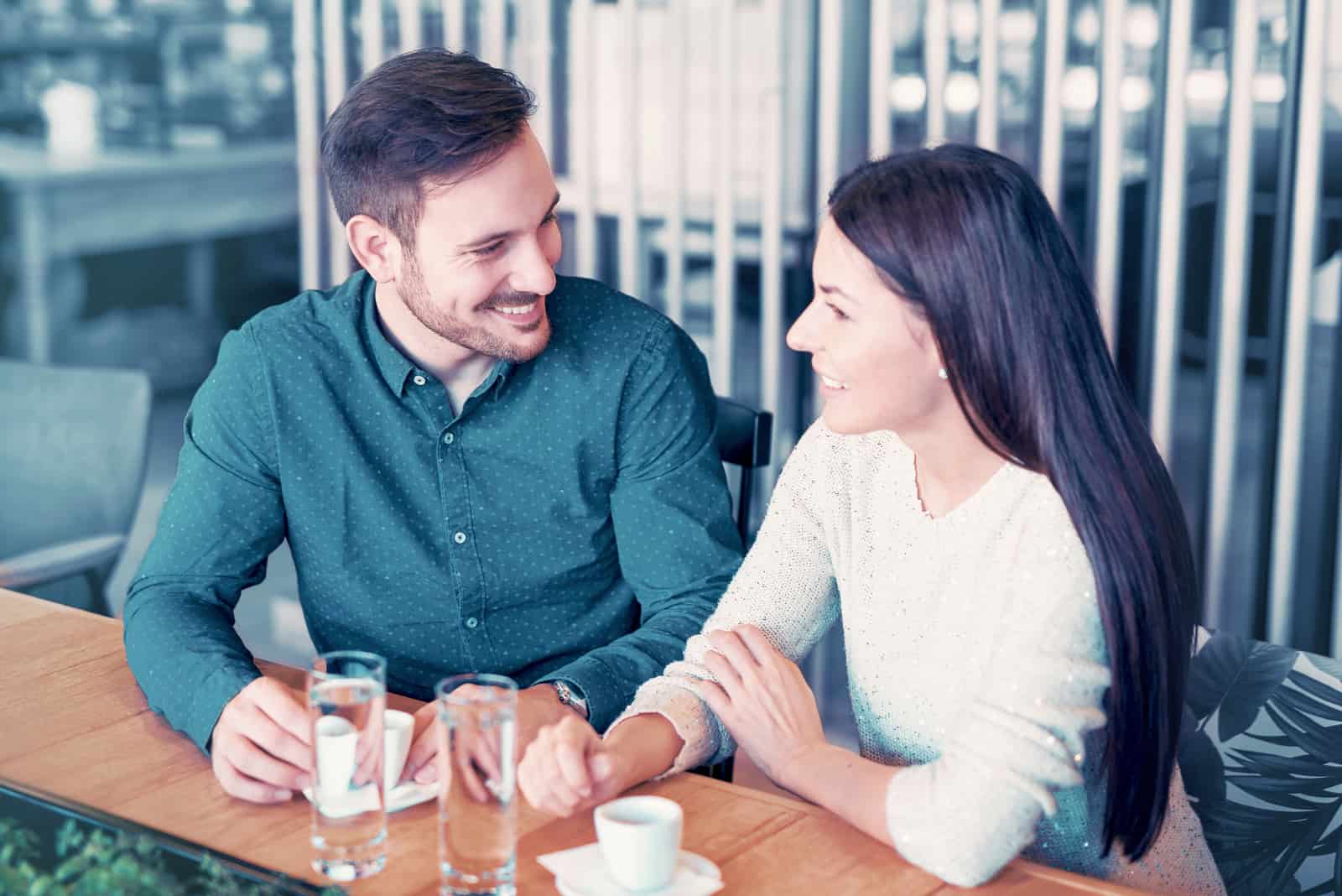 homme et femme discutant assis dans un café