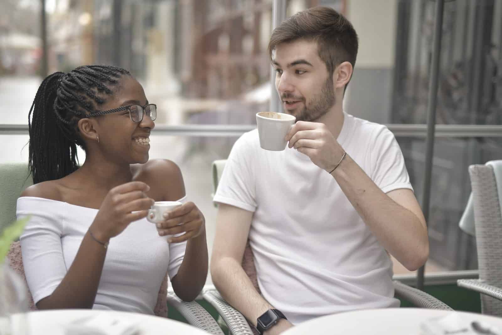 homme et femme buvant du café assis en plein air