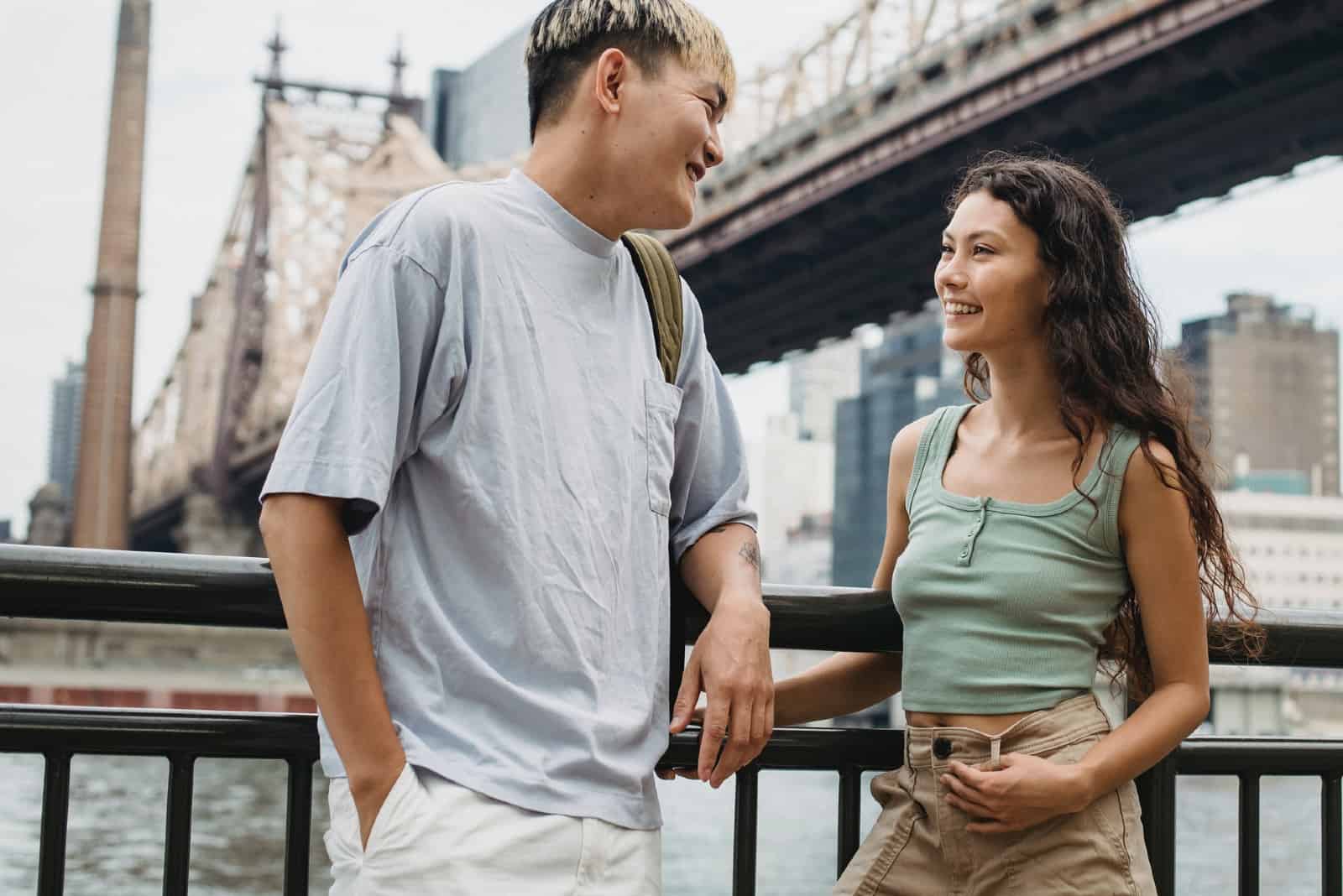 homme et femme souriant près d'un pont