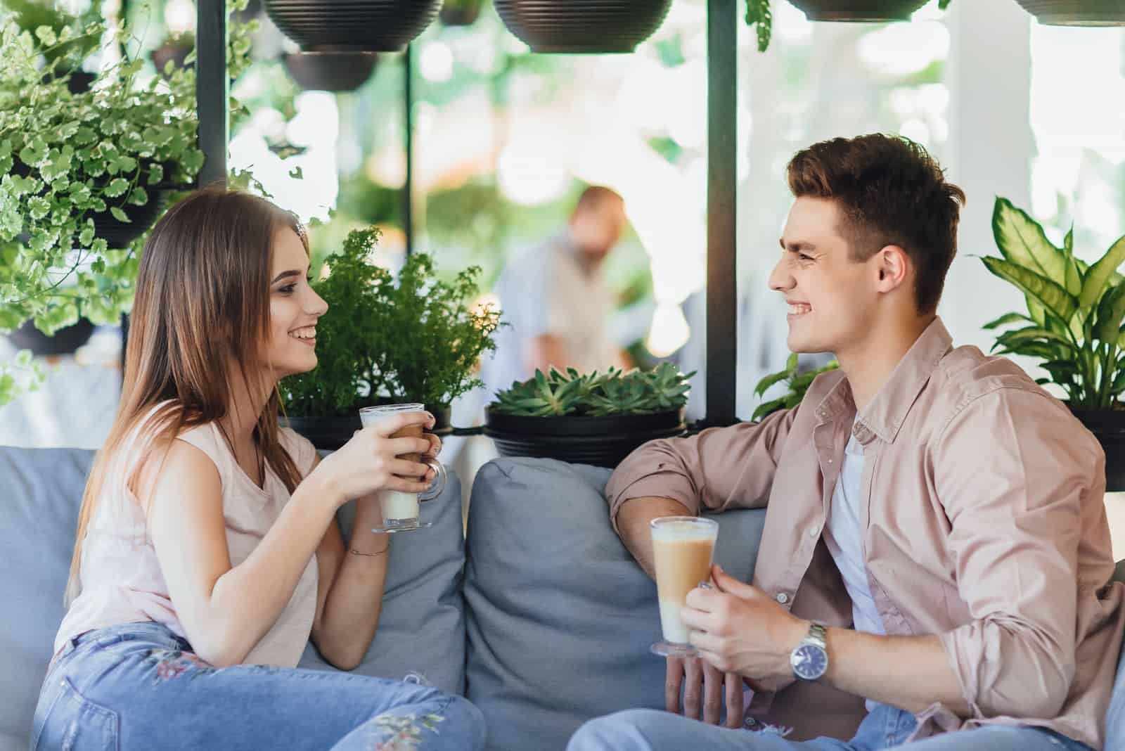 Homme et femme prenant un café assis dans un café.