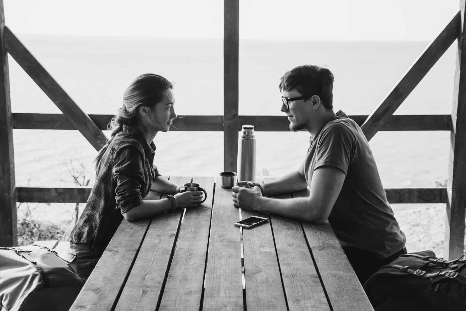 couple se reposant dans une terrasse en bois et se parlant