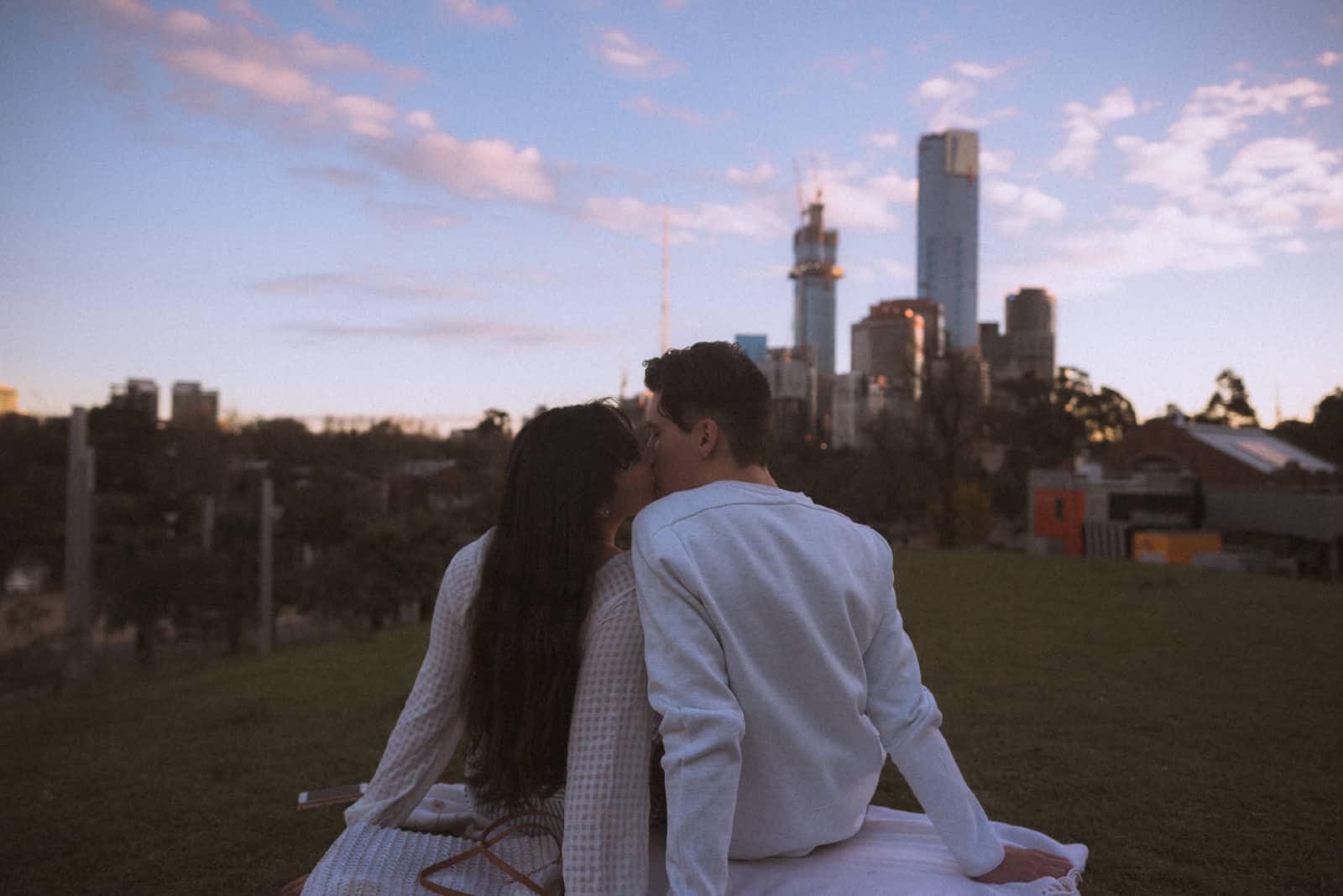 homme et femme s'embrassant assis sur l'herbe