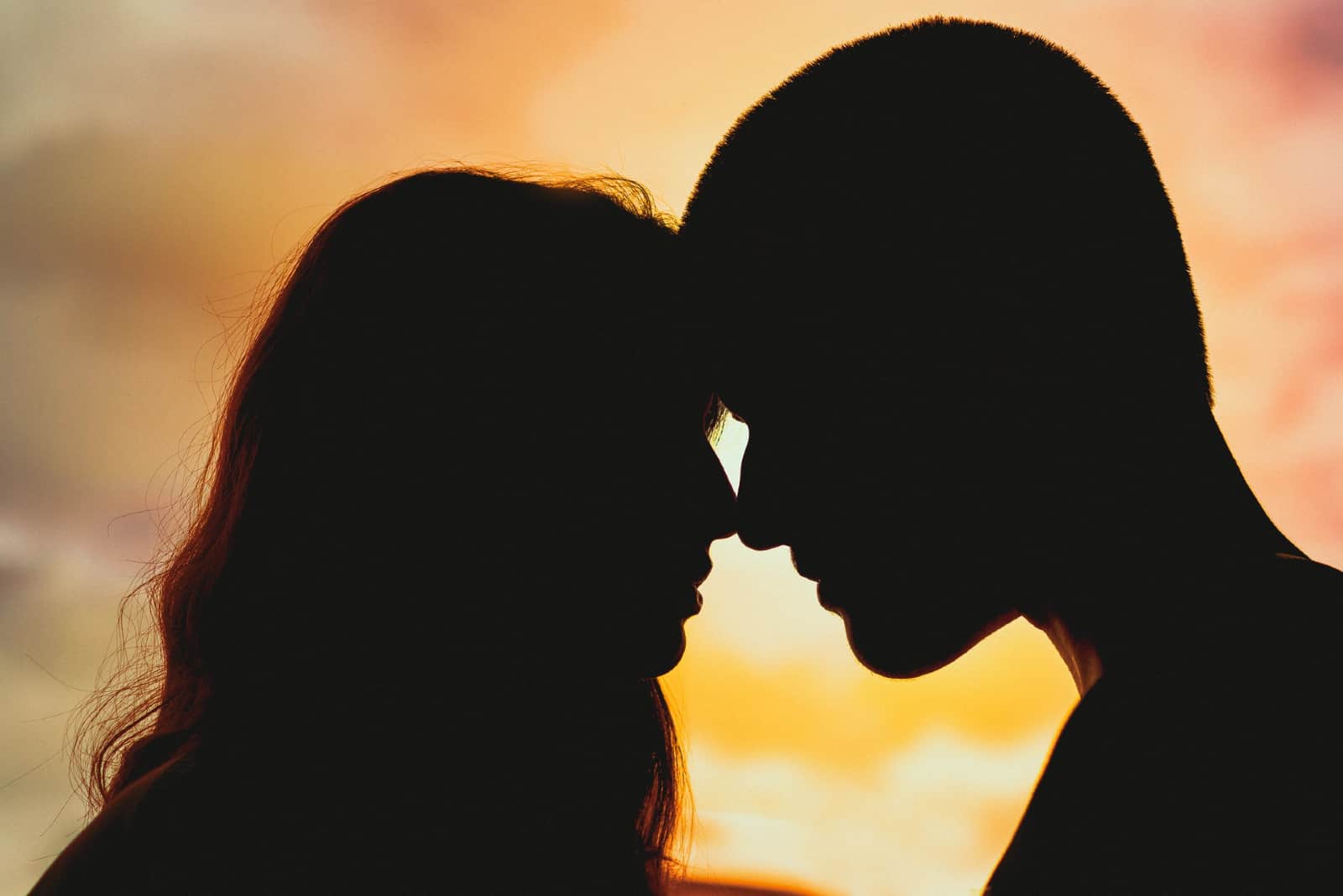 homme et femme sur le point de s'embrasser pendant le coucher du soleil