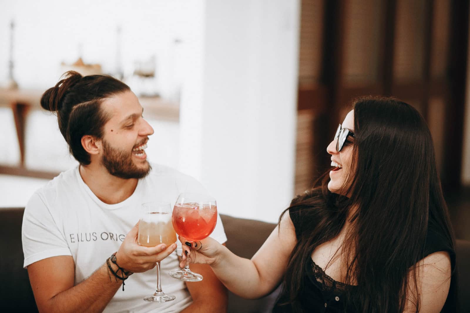 homme et femme souriant en tenant des boissons