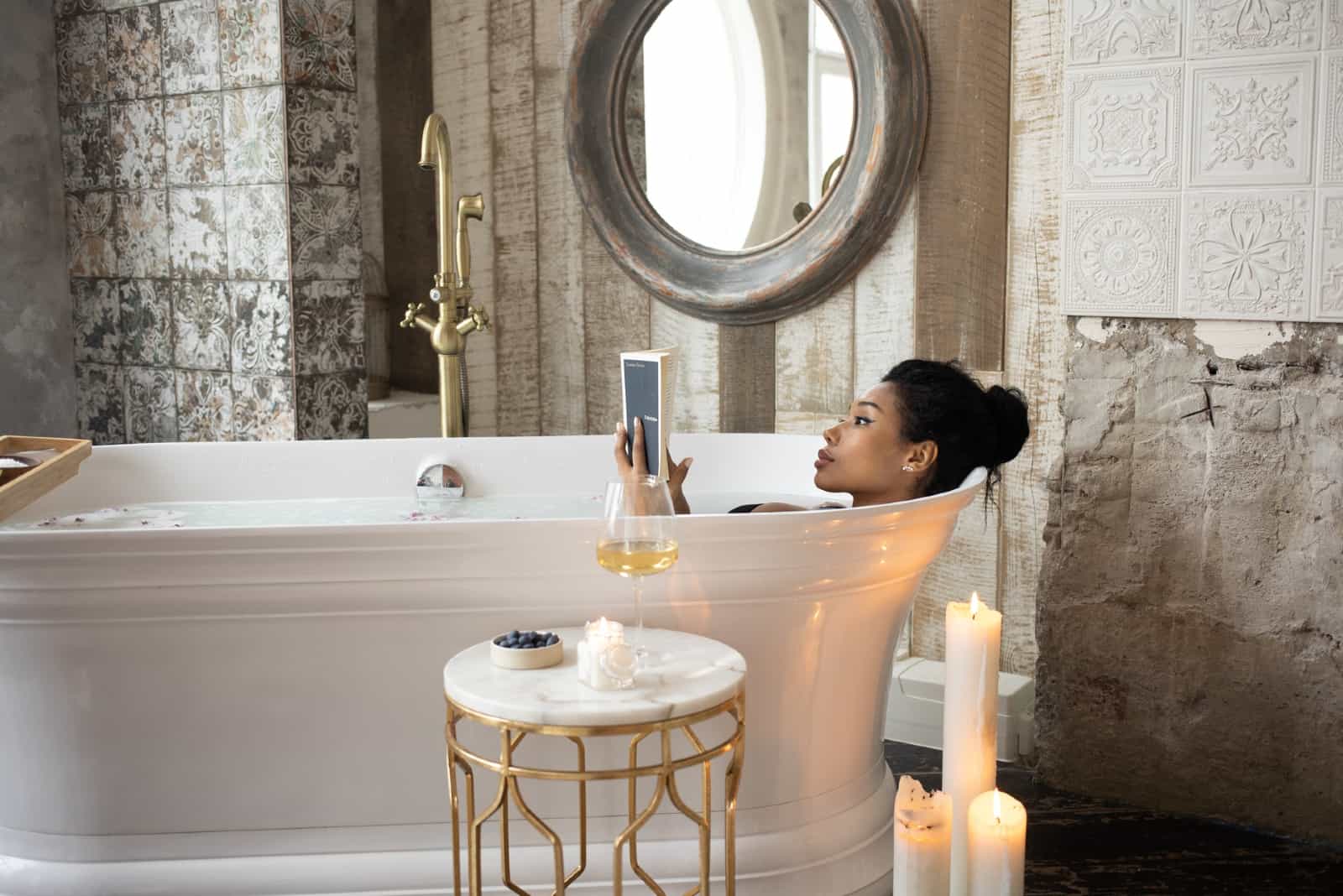 Femme lisant un livre tout en se relaxant dans une baignoire