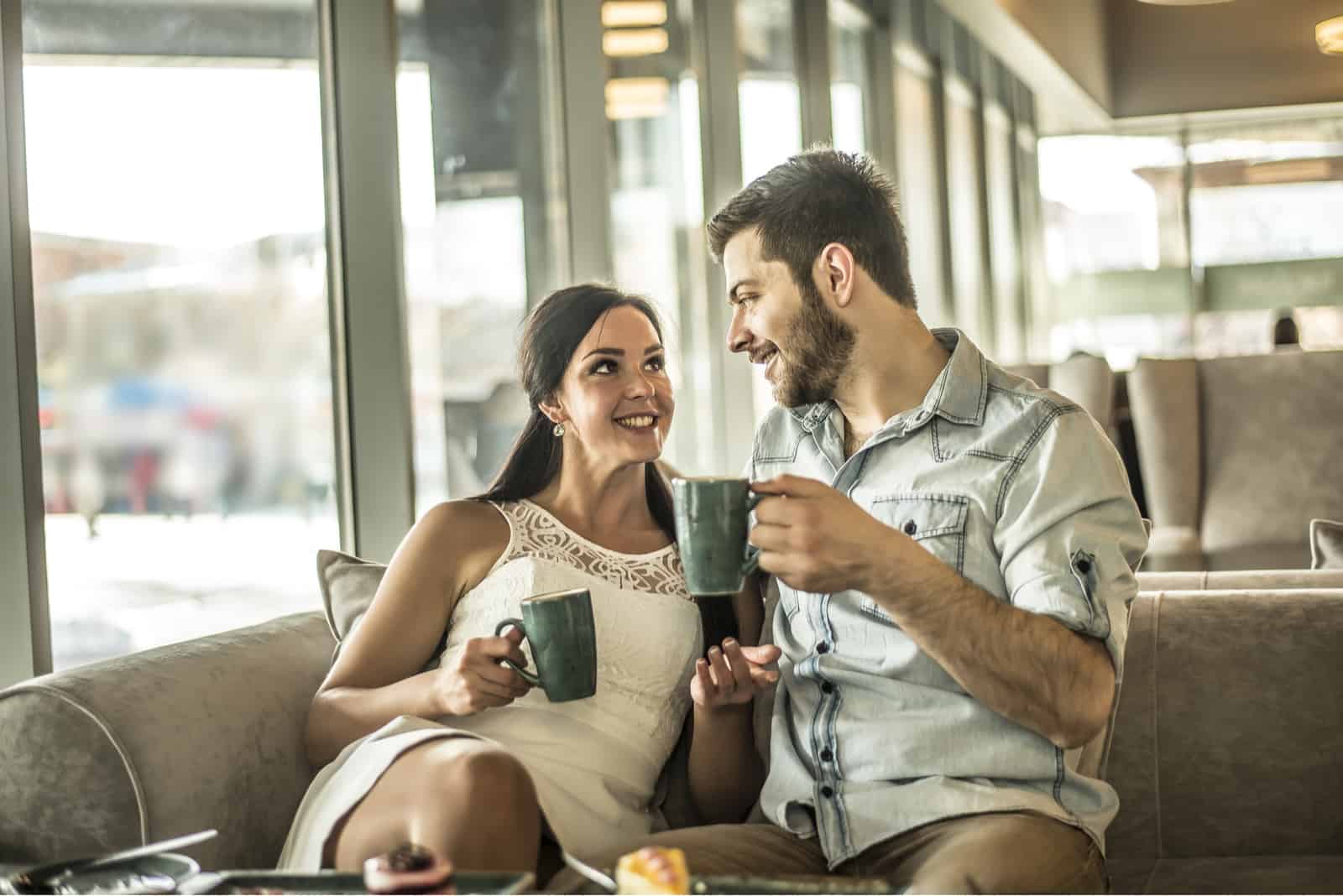 femme parlant à un homme assis dans un café