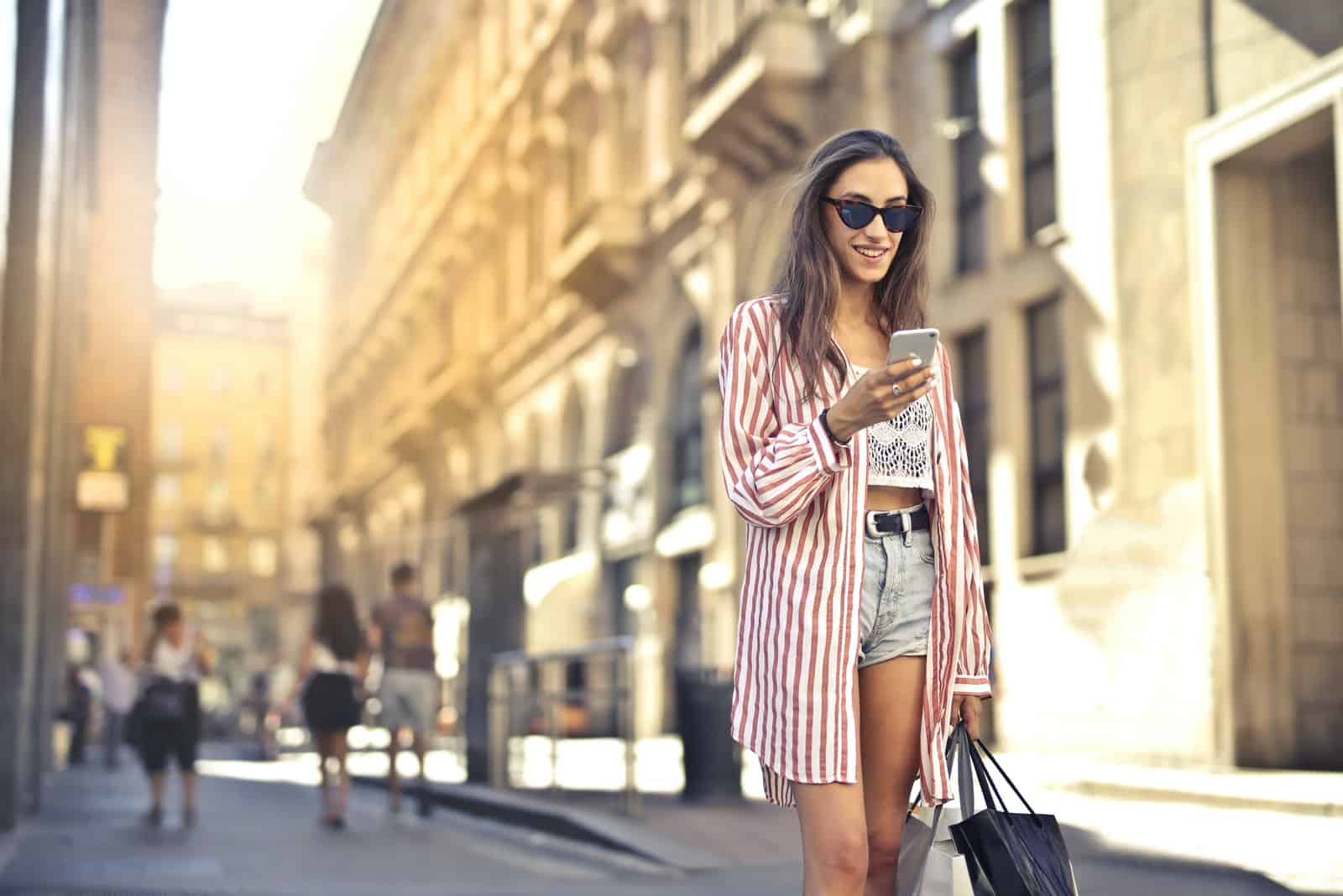 femme regardant son smartphone dans la rue