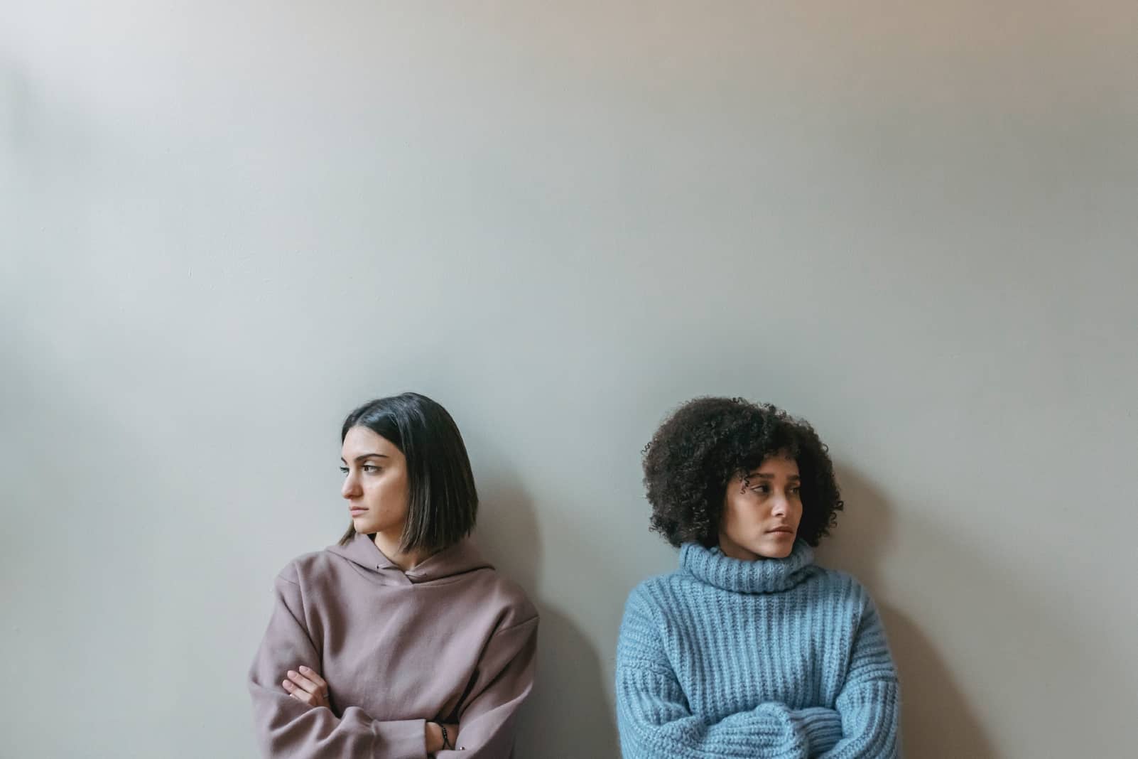 deux femmes tristes assises près d'un mur