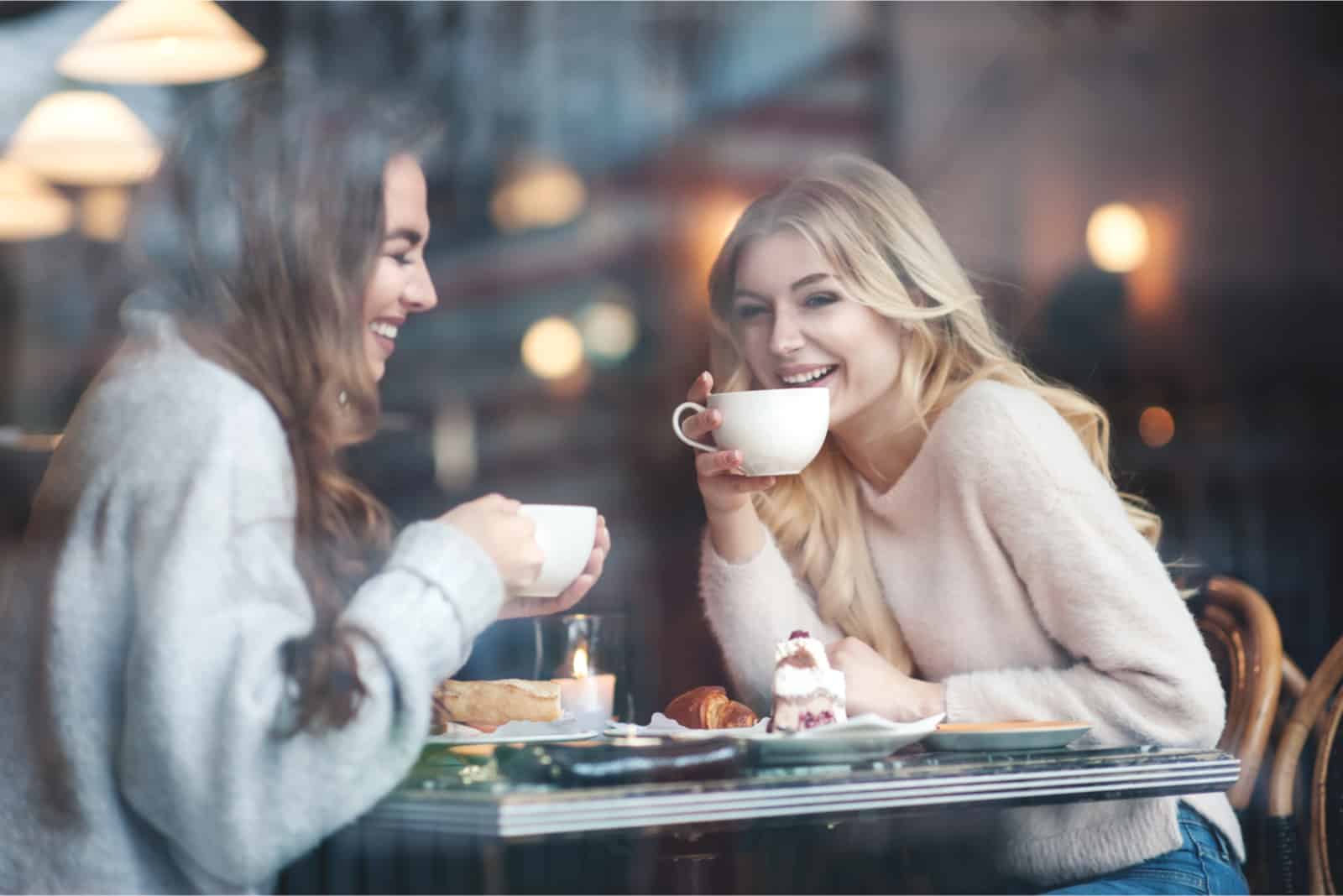 deux femmes buvant du café assises dans un café