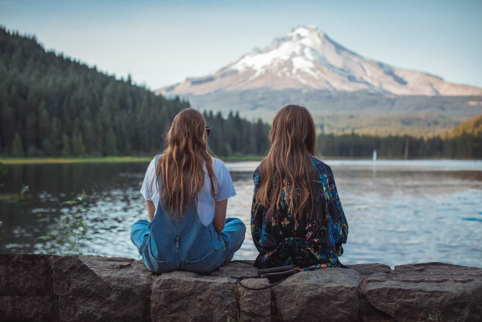 deux femmes aux cheveux longs regardant l'eau