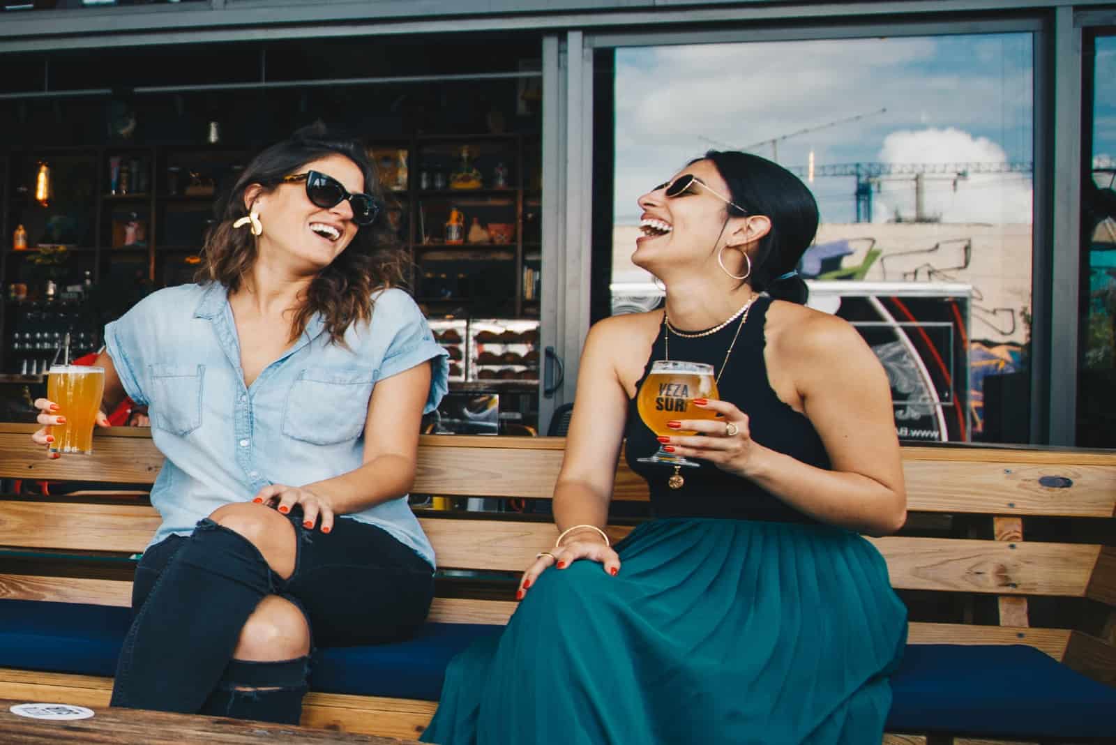 deux femmes souriant en buvant une bière