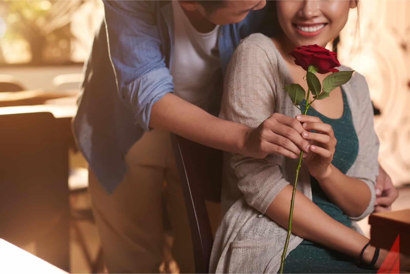 homme offrant une rose rouge à une femme heureuse