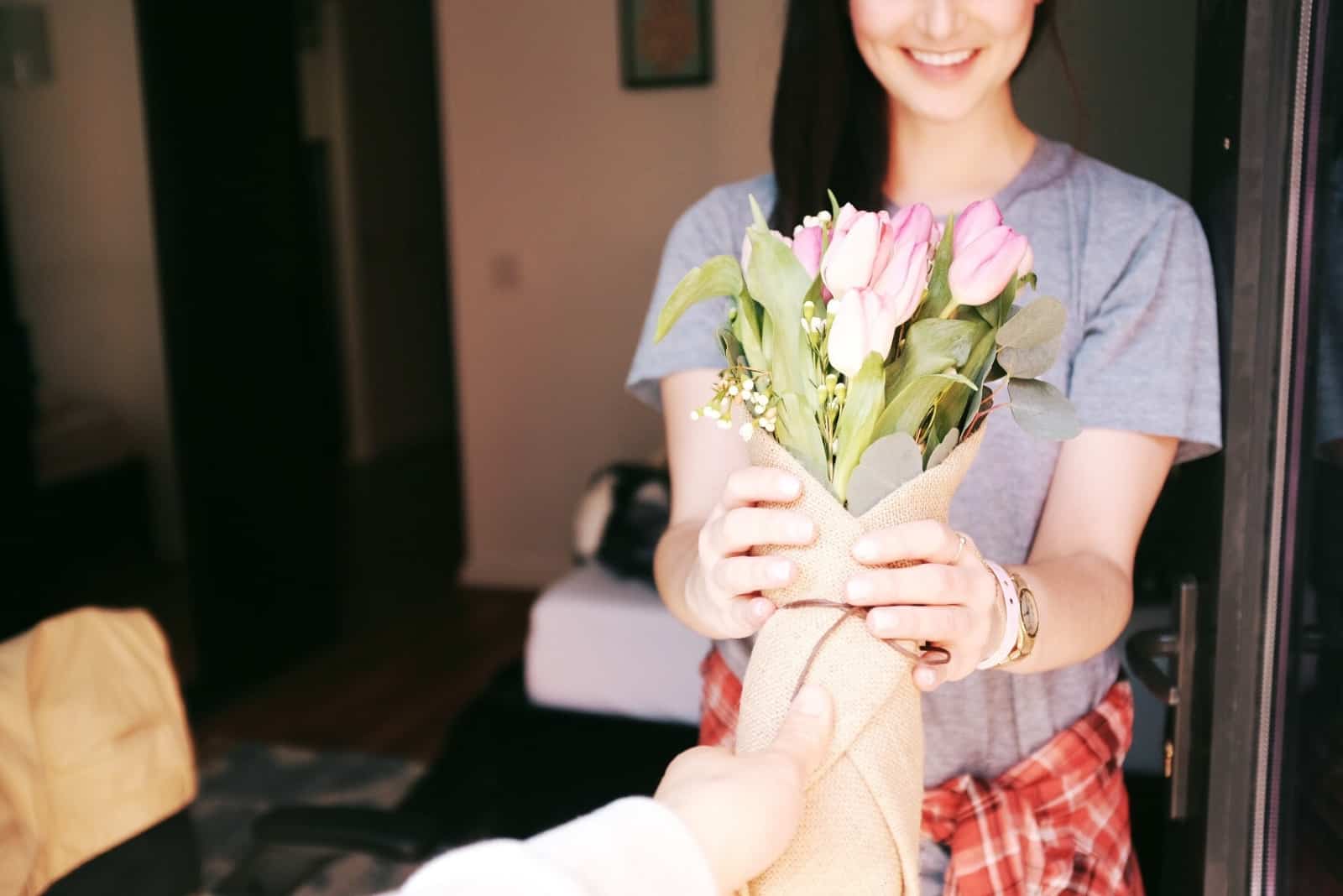 Homme donnant un bouquet de fleurs à une femme heureuse
