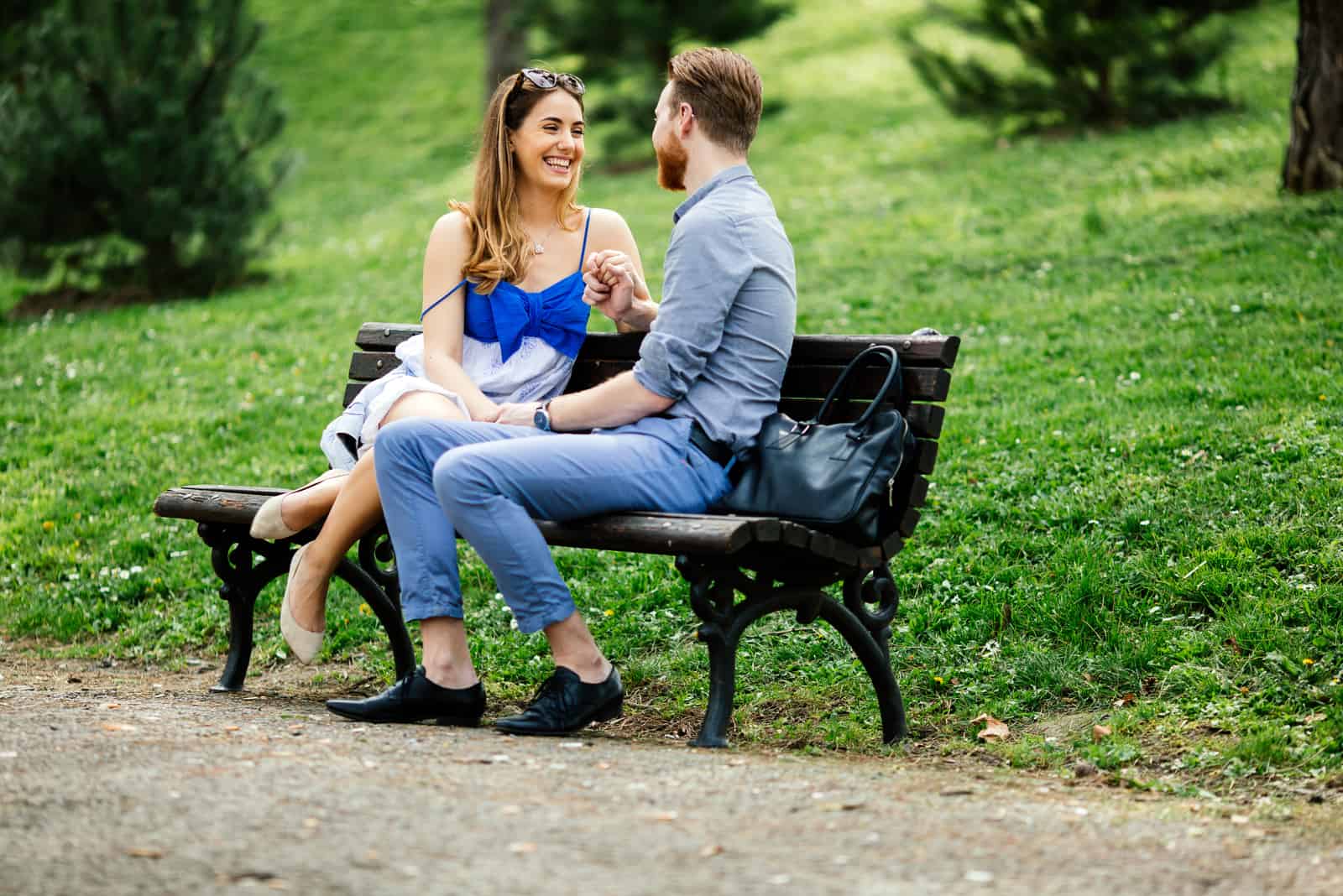 homme tenant la main d'une femme assise sur un banc