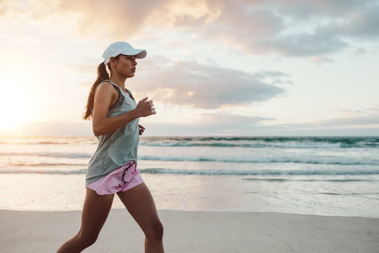 jeune femme dans sportswear jogging sur plage