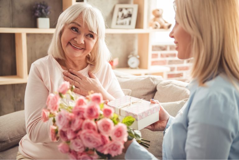 la fille a surpris sa mère avec un bouquet de roses et un cadeau