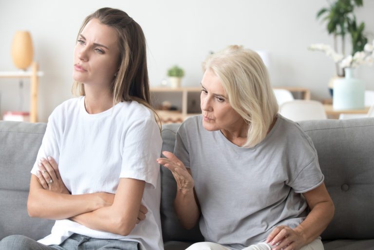 mère parlant à sa fille assise sur un canapé