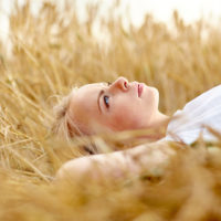 une femme aux cheveux blonds se trouve dans un champ de blé