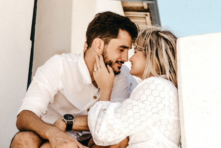 femme en blouse blanche touchant le visage d'un homme