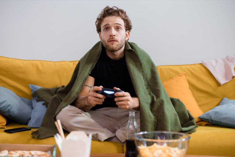 homme jouant à des jeux assis sur un canapé
