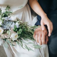 un homme et une femme s'assoient et tiennent un bouquet à la main