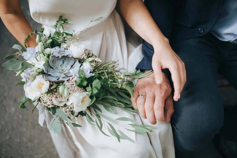 un homme et une femme s'assoient et tiennent un bouquet à la main