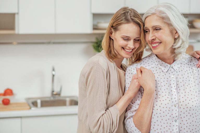embrasser la mère et la fille debout dans la cuisine