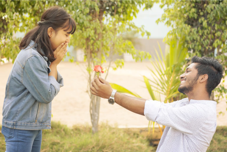 un homme amoureux donne une rose à une fille surprise