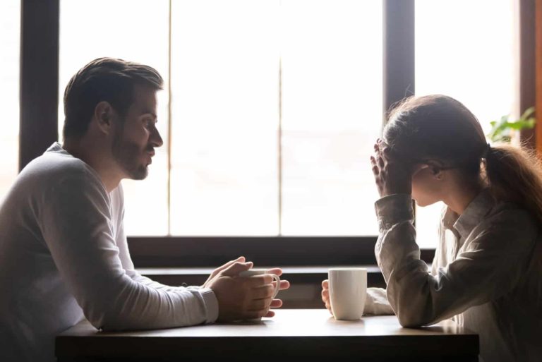 un homme et une femme sont assis à une table et parlent