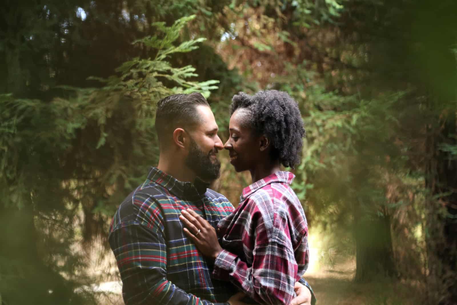 homme et femme s'embrassant dans une forêt