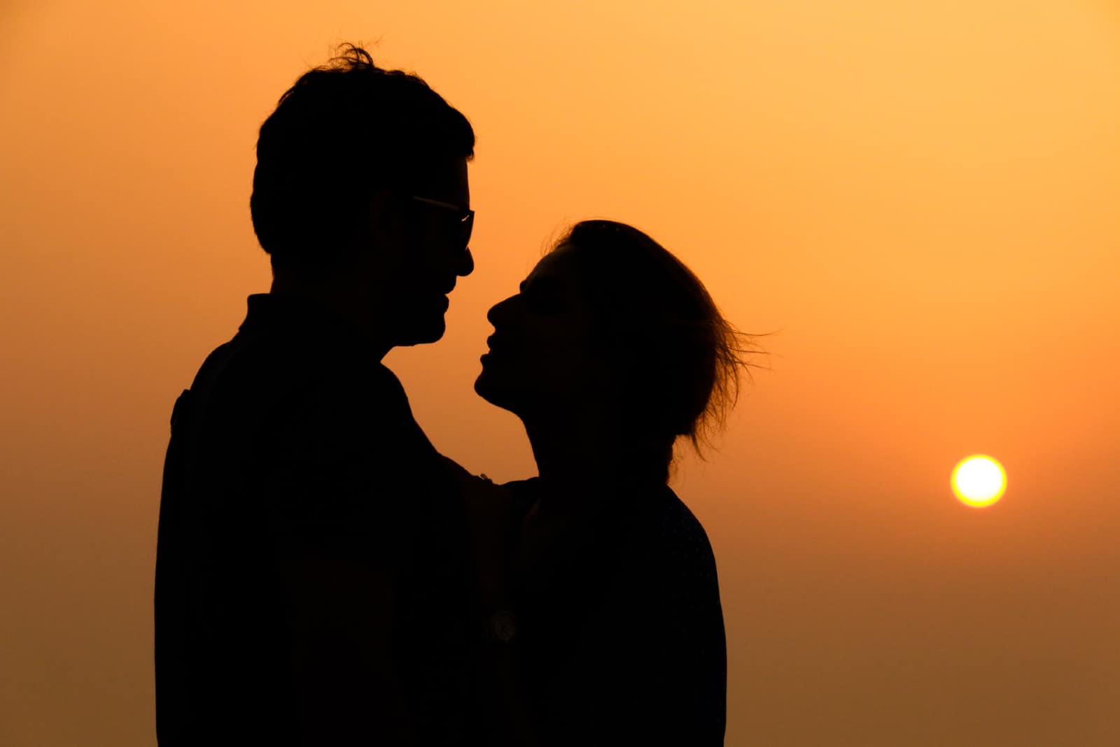 homme et femme se regardant dans les yeux au coucher du soleil