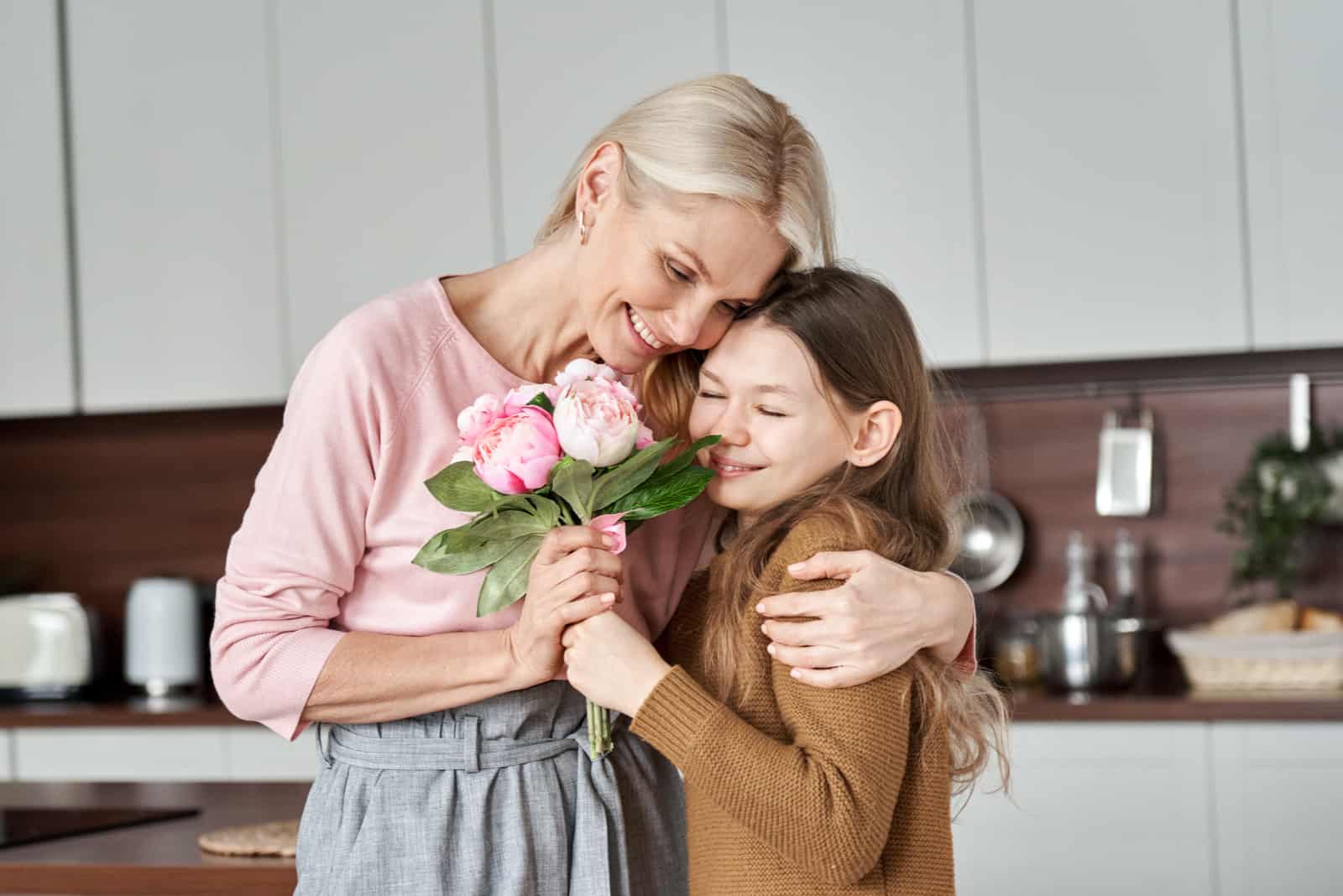 sa fille a donné des fleurs à maman qu'elle a serrée dans ses bras