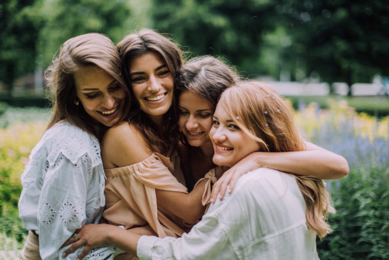 quatre femmes s'embrassant en plein air