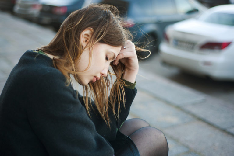 une femme inquiète est assise dans les escaliers