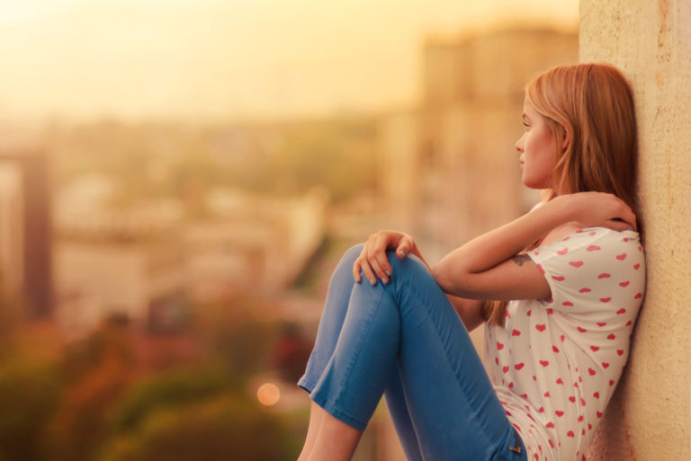 la femme est assise appuyée contre le mur