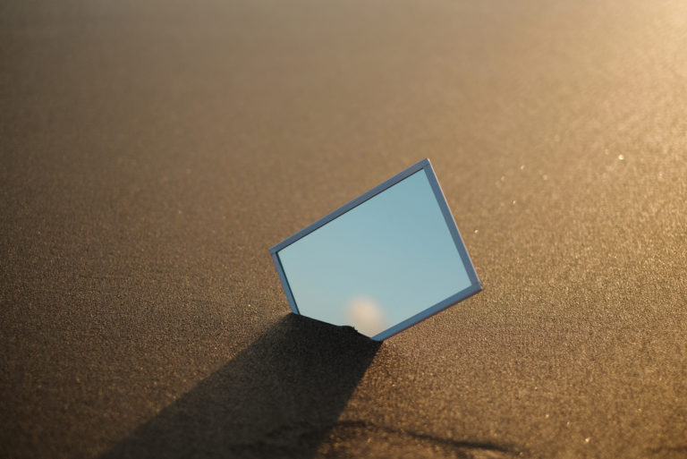 un miroir placé dans le sable de la plage