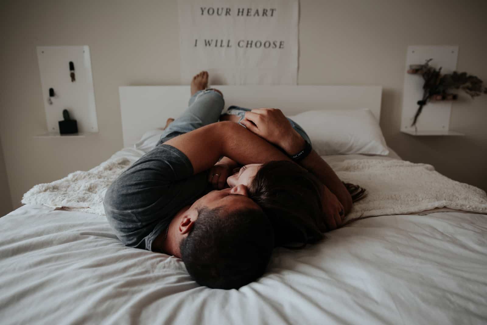 homme et femme se câlinant sur un lit
