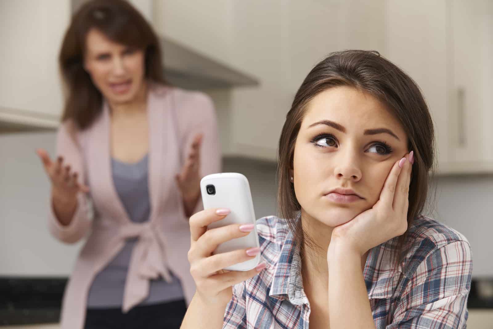mère hurlant sur sa fille avec un smartphone